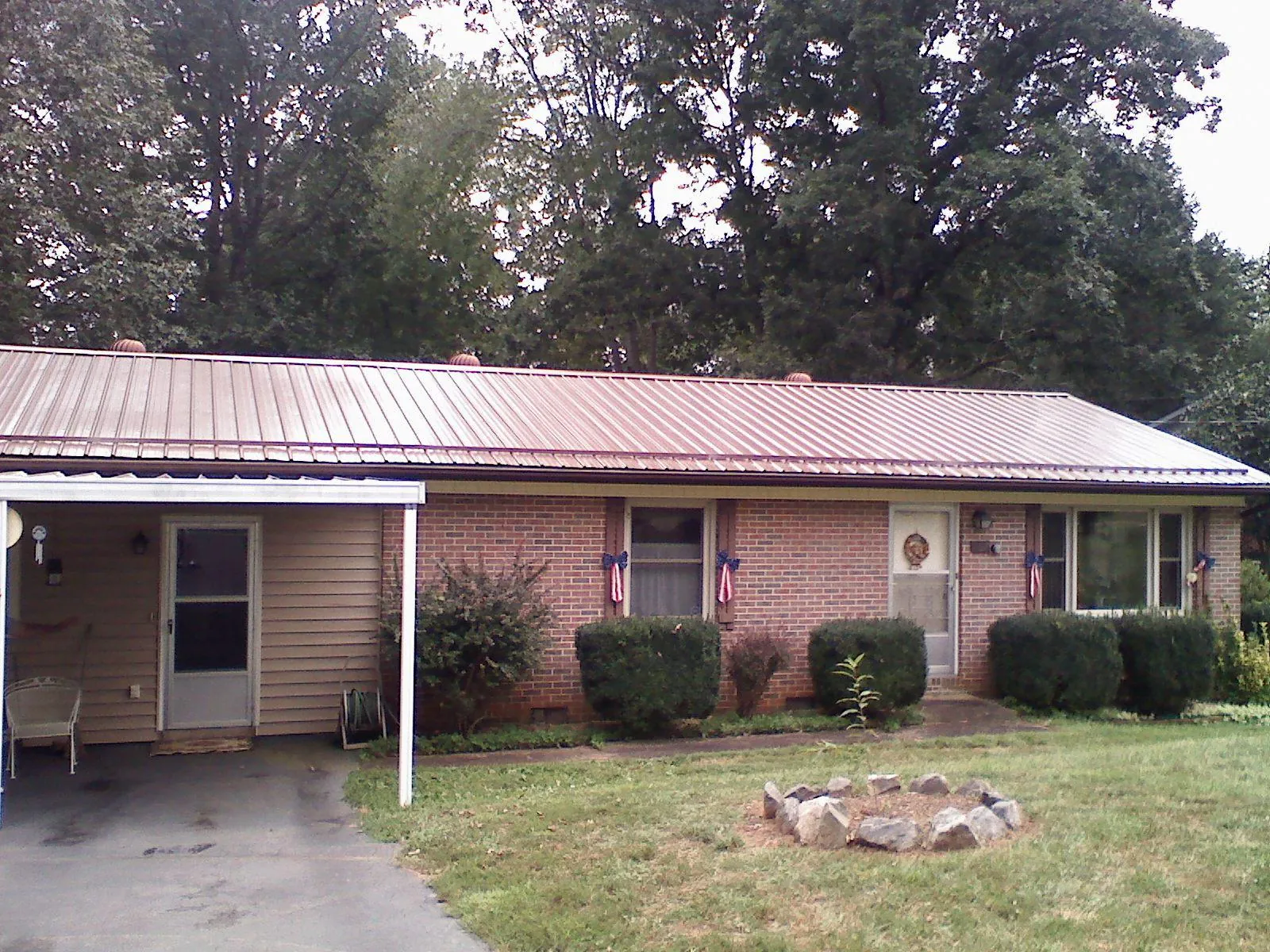 Bronze metal roof and carport on a brick ranch home — Roof Repair work by our crew in Albertville